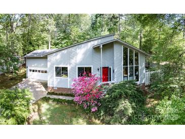 Modern home featuring a red front door, lots of window space, and landscaped bushes and trees at 114 Walnut Creek Rd # 24, Belmont, NC 28012