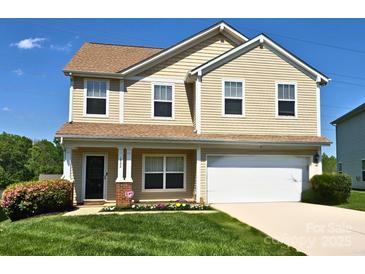 Charming two-story home with a well-manicured lawn, attached garage, and inviting front porch at 1522 Ladora Dr, Charlotte, NC 28262