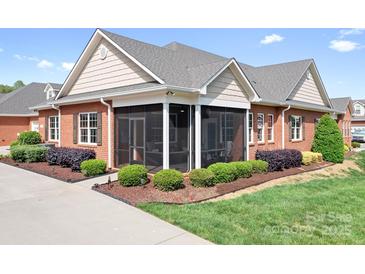 A charming red brick home with a screened-in porch and well-manicured landscaping at 2334 Sylvia Ct, Denver, NC 28037