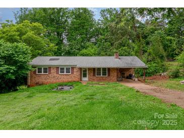 Cozy brick ranch-style home with lush greenery and a covered carport at 302 Kimberlee Dr, Shelby, NC 28152