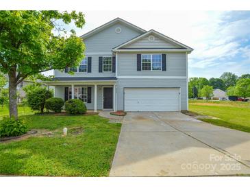 Two-story home featuring a two-car garage, front porch, and lush green lawn at 5219 Biederbeck Dr, Charlotte, NC 28212