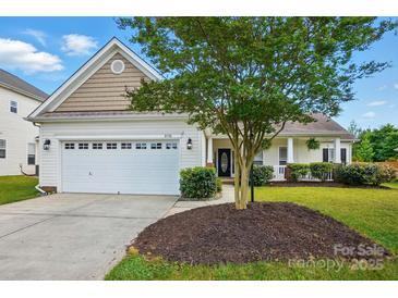 Charming single-Gathering home showcasing a well-maintained lawn, attached garage, and inviting front porch at 8726 Castle Cliff Dr, Matthews, NC 28105