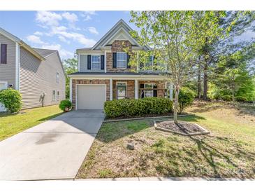 Charming two-story home with stone accents, a covered porch and lush landscaping at 9527 Turning Wheel Dr, Charlotte, NC 28214