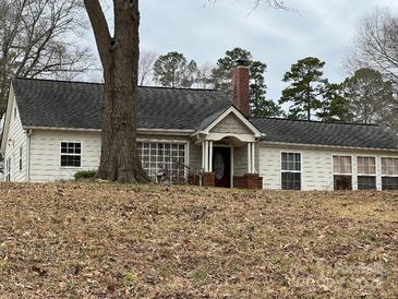 Ranch style home featuring brick chimney, covered front porch, and neutral siding at 14131 Lucia Riverbend Hwy, Mount Holly, NC 28120