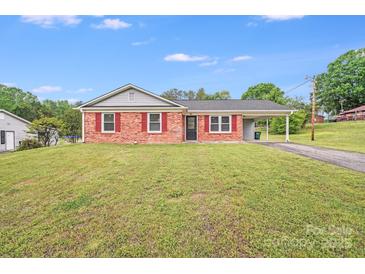 Charming one-story home with red shutters, a well-manicured lawn, and a convenient covered carport at 218 Valleybrook Ln, Troutman, NC 28166