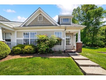 Charming single-story home with a well-maintained lawn and inviting entrance with brick pillar and concrete steps at 3219 Cottage Rose Ln, Rock Hill, SC 29732
