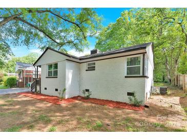 Charming white brick home featuring classic architecture, complemented by a well-maintained lawn and mature trees at 3300 Bonaire Dr, Charlotte, NC 28208