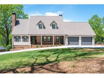 Charming home with brick accents, dormer windows, two-car garage, and a well-manicured lawn at 3755 11Th Ne St, Hickory, NC 28601