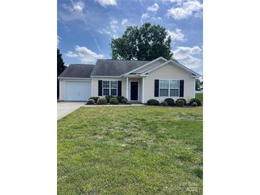 Charming single-story home featuring a manicured lawn and attached garage, perfect for first-time buyers at 5012 Wheat Sw Dr, Concord, NC 28027