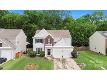 Charming two-story home with a well-manicured front yard and attached two-car garage at 8800 Darcy Hopkins Dr, Charlotte, NC 28277