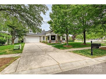 Charming home with well-manicured lawn, inviting front porch, and a spacious driveway leading to a two-car garage at 1000 Millbank Dr, Matthews, NC 28104