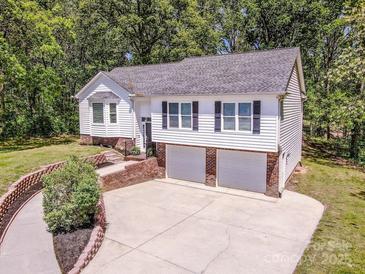 Charming two-story home with white siding and a two-car garage at 142 Gray Barn Dr, Troutman, NC 28166