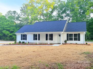 Charming single-story home with a blue roof, white siding, black shutters, and a freshly mulched front yard at 288 Tram Rd, Lancaster, SC 29720