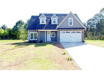 Charming home featuring a two-car garage, stone accents, and a well-manicured lawn at 300 Southern Oaks Ln, Salisbury, NC 28147