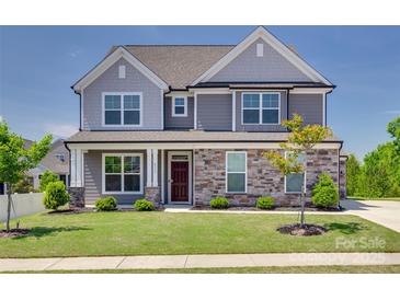 Two-story home featuring stone accents, gray siding, manicured lawn, and professional landscaping at 6113 Russo Ct, Lancaster, SC 29720