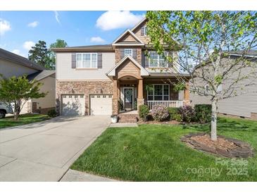 Charming two-story home with stone accents, manicured lawn, attached two-car garage and a welcoming covered front porch at 10116 Garman Hill Dr, Charlotte, NC 28214