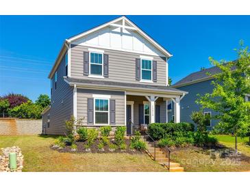 Charming two-story home with gray siding, black shutters, and a well-manicured front yard at 13210 Kenworth Rd, Charlotte, NC 28278