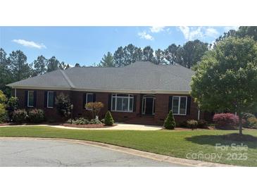 Charming brick home featuring manicured landscaping, a well-kept lawn, and classic architectural details at 216 Commodore Ct, Belmont, NC 28012