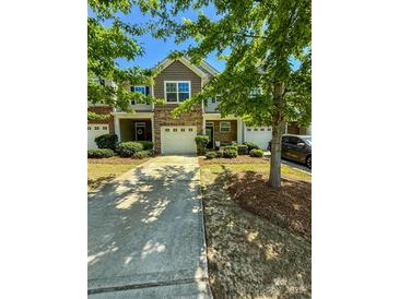 Charming townhome featuring a well-manicured lawn, brick accents, and a private driveway leading to an attached garage at 2752 Sawbridge Ln, Gastonia, NC 28056