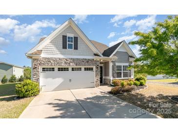 Charming home featuring stone accents, a two-car garage, and well-maintained landscaping at 338 Livingston Dr, Lancaster, SC 29720