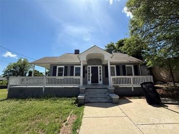 Charming gray home with a covered porch, black shutters and a quaint, inviting front yard at 406 S Catawba St, Lancaster, SC 29720