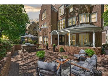 This outdoor patio is brick paved with an outdoor dining table, grill, and outdoor furniture at 423 N Pine St, Charlotte, NC 28202