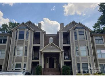 Inviting condo with a covered entrance, private balconies, and neutral siding providing an appealing exterior at 6234 Rosecroft Dr, Charlotte, NC 28215