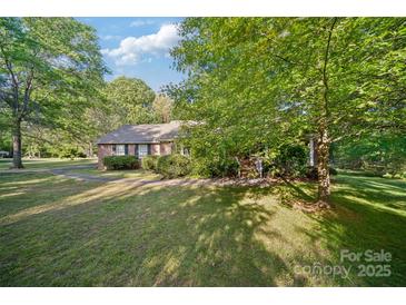 Charming brick home with mature trees and lush landscaping creates a peaceful, inviting curb appeal at 8222 Henry Harris Rd, Fort Mill, SC 29707