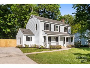 Charming two-story home with light blue siding, black shutters, and a welcoming front porch at 910 Lightwood Dr, Matthews, NC 28105