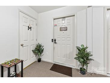 Welcoming entryway features neutral tones, sleek doors, and decorative plants adding a touch of greenery at 123 Carriage House Dr, Kannapolis, NC 28081