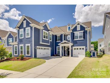 Beautiful blue two-story home with three-car garage and manicured lawn at 14925 Baldridge Dr, Huntersville, NC 28078