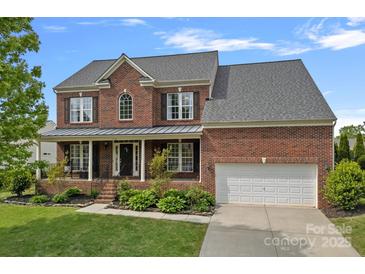 Beautiful two-story brick home with a manicured lawn, covered porch, and two car garage at 156 Pecan Hills Dr, Mooresville, NC 28115