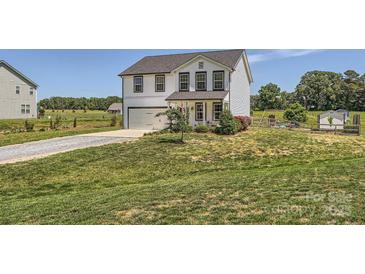 Charming two-story home features a well-manicured lawn and attached garage at 2206 Mills Harris Rd, Wingate, NC 28174
