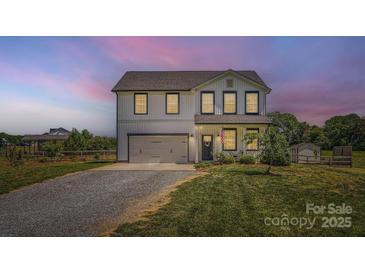 Charming two-story home with a gray garage door, manicured lawn and inviting front porch at 2206 Mills Harris Rd, Wingate, NC 28174