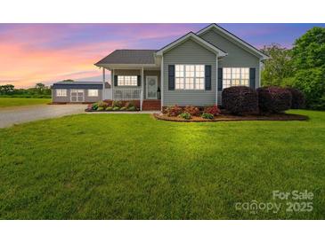 Charming single-Gathering home featuring a large front yard, cozy porch, and a detached storage shed at 2225 Corinth Church Rd, Monroe, NC 28112