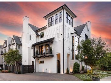 Striking modern home with a painted brick facade, multiple balconies, and a brick driveway at 443 Beaumont Ave, Charlotte, NC 28204