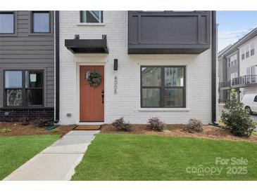 Stylish townhome exterior with brick, modern black accents, and a welcoming front door with green wreath at 6005 Countess Dr # 49, Charlotte, NC 28217