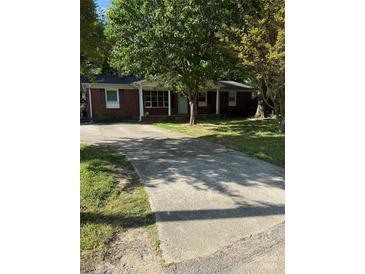 Charming brick home featuring a large driveway and a welcoming front porch at 918 Carmel Dr, Gastonia, NC 28056