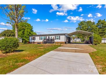 Charming single-story home with ample parking, canopy, and manicured lawn under a bright, sunny sky at 114 Doubletree Dr, Statesville, NC 28677