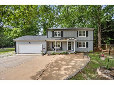 Charming two-story home with a covered front porch, an attached garage, and a well-manicured lawn at 130 Cherokee Ln, Salisbury, NC 28147