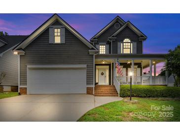 Charming two-story home boasts a welcoming front porch, neutral siding, a two-car garage, and well-maintained landscaping at 1358 Colwick Ln, Rock Hill, SC 29732