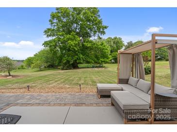 Inviting outdoor patio featuring a shaded seating area and expansive lawn, perfect for relaxation at 176 Jennymarie Rd, Mooresville, NC 28115