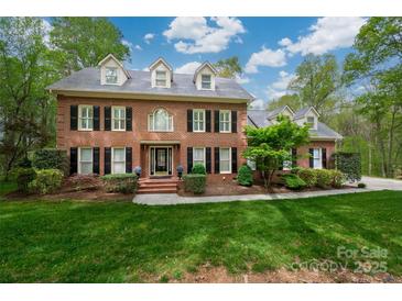 Traditional brick home with black shutters, dormer windows, and professionally landscaped front yard at 2306 Beechwood Dr, Waxhaw, NC 28173