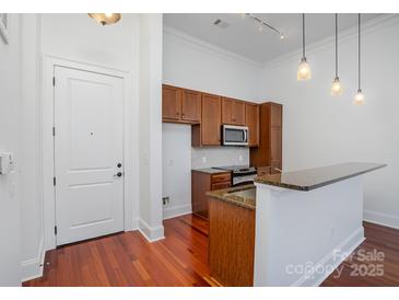 An efficient kitchen features stainless appliances, granite countertops, and a practical breakfast bar at 2810 Selwyn Ave # 410, Charlotte, NC 28209