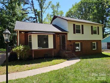 Charming two-story home featuring brick and vinyl siding, with a well-maintained front lawn and mature trees at 6212 Snowcrest Ct, Charlotte, NC 28212