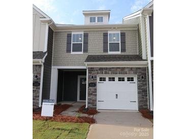 Charming townhouse with stone accents, a one-car garage, and a well-maintained lawn at 1115 Overbrook Pl, Wingate, NC 28174