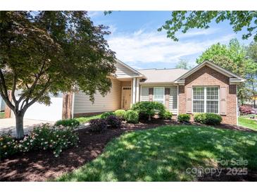 Charming home with a well-maintained lawn, beautiful landscaping, and a mix of brick and siding at 134 Walmsley Pl, Mooresville, NC 28117