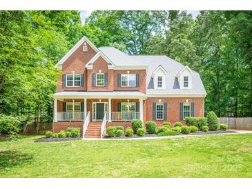 Charming two-story brick home with a welcoming front porch and beautifully landscaped front yard at 141 Culpeze Rd, Mooresville, NC 28117