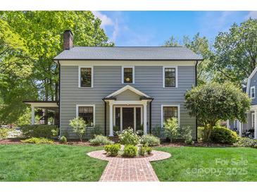 Charming two-story home with a well-manicured lawn, brick walkway, and lush landscaping at 1726 The Plz, Charlotte, NC 28205