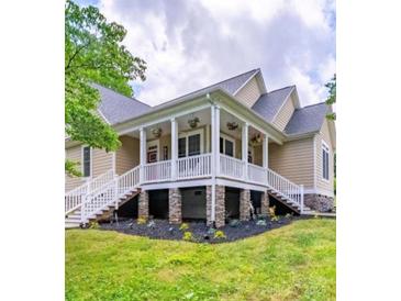 Inviting home featuring a charming front porch with classic railings and stone accents at 206 Montclair Dr, Locust, NC 28097